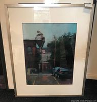 Full view of one framed artwork leaning against wall, showing mat and frame