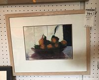 Full front view of framed and matted artwork hanging on pegboard with auction tag