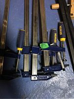 Close-up of two Irwin F-style bar clamps with green tags marking 27" length