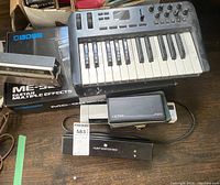 Oxygen 25 keyboard, Boss ME-90 box, Heine mini handle and Hunt medical light unit on tabletop