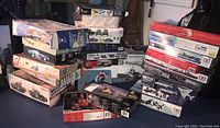 Overall photo showing stacked model kit boxes of military vehicles, aircraft, and cars