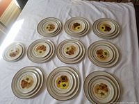 Top view of arranged plates in three stacks showing floral design with yellow, brown, and orange flowers and brown rim on cream background.