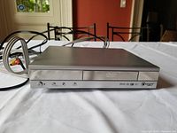 Front view of silver Daytek DVD player showing power and control buttons and DVD logo.