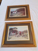 Two framed hunting scene prints side by side showing detailed hunting party scenes.