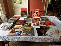 Overview of large collection of music-related books and musical programs arranged on a table.