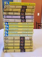 Books stacked showing mostly spine titles with some duplicates like The Mystery at Lilac Inn and The Hidden Staircase