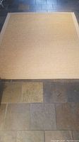 Full view of natural sisal carpet on stone tile floor