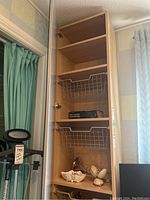 Tall interior view showing adjustable top shelf, fixed wood shelf and five wire baskets.