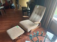 Front-left perspective of lounge chair with matching ottoman on hardwood floor