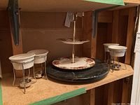Photo showing marble lazy Susan base, two-tier floral cake tray, and three white ceramic sauce warmer ramekins with metal stands