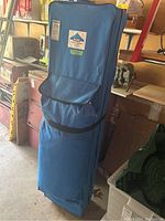 Front view of blue wheeled storage bag with Uline label and wheels at base