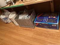 Photo showing Chinet luncheon plates, a silver box containing piping bags, and a box of Kirkland crystal clear cutlery 360 pieces.