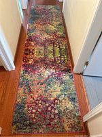 Full view of multicolor runner placed in hallway showing length and pattern.