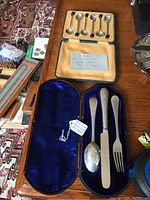 Six-piece set of small silver spoons in lined case, showing satin interior and note