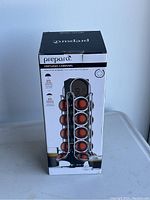 Photo of boxed Prepara Vertuoso carousel coffee capsule holder showing capsule storage capacity and brand.