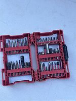 Red plastic case open displaying 40 assorted drill and driving bits, various tip types visible.