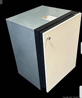 Front angled view showing off-white door with a small squared chrome handle and silver metal sides.