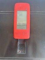 Front view of red Mpower Echelon wired console device showing the LCD screen with display readings and three front buttons. Attached metal mounting bracket visible below console.