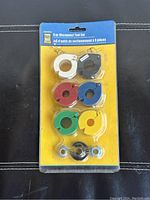 Photo of 9 piece disconnect tool set in blister packaging showing six colored tools (red, blue, green, yellow, white, black) and three small fittings