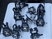 Top view of 10 Echelon Connect EX1 clip pedals showing mostly black pedals with metal clip cleats and spindles organized on flat surface.