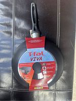 Photo of the wok bottom side showing the product label and handle attachment area with T-fal Viva branding.