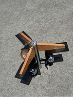 Overhead angled view of vintage electric fixture showing three wooden arms with metal accents and bulb housings.