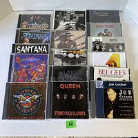 Photo of 15 CDs in jewel cases featuring various rock artists and album titles visible.