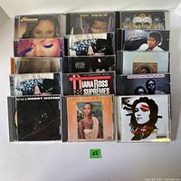 Photo shows a collection of 15 used music CDs from various artists including Rihanna, Michael Jackson, Muddy Waters, Whitney Houston, Diana Ross, BB King, Madonna, Chris Brown, and Rhythm Nation.