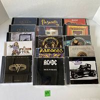 Photo showing 15 used classic rock music CDs in jewel cases including Queen, Nazareth, Meat Loaf, Steppenwolf, Ramones, Whitesnake, Van Halen, AC/DC, Aerosmith and others.