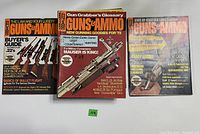 Three vintage Guns & Ammo magazines laid side-by-side showing front covers with firearm-related headlines and images.