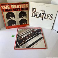 Photo showing three Beatles albums: 'A Hard Day's Night', 'The Beatles 20 Greatest Hits', 'The Beatles 1962 to 1966'.