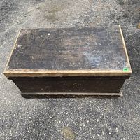 Front view of closed vintage wooden box with visible wear on surface.