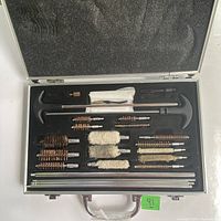 Opened case showing full firearm cleaning kit layout with various brushes, mops, rods, and T-handles.