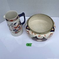 Top and side view of the Burleigh Ware Japonica pitcher and H R S & Co. ceramic bowl showing decorative floral and leaf patterning, with blue handle on pitcher and geometric design on bowl.