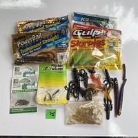 Image showing multiple packages of soft plastic fishing baits and hooks including Berkley PowerBait, Berkley Gulp! Slurpies, Bell hooks, and loose soft plastics shaped as worms and minnows.