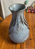 Side angle of Blue Mountain Pottery vase showing its textured slate glaze and flared neck.