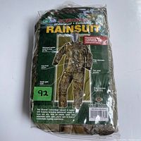 Packaged new camouflage waterproof rain suit in sealed plastic bag, front displaying product features and image of the suit.