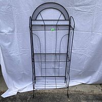 Front view of the vintage folding wire shelf, showing full height and all three wire shelves with the arch detail on the back.