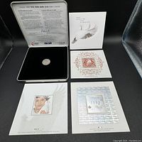 Full set of the keepsake tin with medallion on black velvet insert and three distinct Canadian commemorative stamps arranged outside.