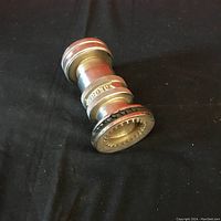 Photo showing angled top view of vintage brass fire hose nozzle with chrome plating, visible knurled grip and threaded hose connection.