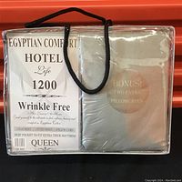 Front view of the unopened package showing brand Egyptian Comfort Hotel Life 1200 and details about wrinkle free fabric, contents, and queen size.
