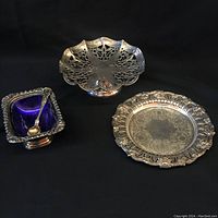 Overall trio view showing footed basket tray, round tray, and blue lined condiment dish with spoon.