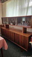 Full view of the buffet and glass hutch, showing wooden finish, glass panels, and overall design.