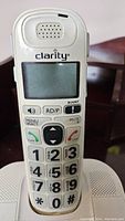 Close-up image of the Clarity branded cordless phone handset showing the screen, speaker, and extra large black numbers on a white keypad.