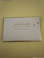 Photo of sealed package with 'JEWELRY Fashion' printed on card inside packaging.