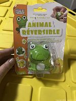 Front view of unopened packaging showing the green frog in blister pack with brand Deux Mômes and labeling in French.