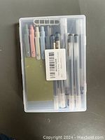 Clear plastic case with 8 pens inside, 4 colored capped pens and 4 black ink pens, unopened packaging.