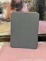 Closed view of gray protective tablet case with tri-fold cover.