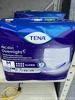 Photo of blue and purple package of TENA ProSkin Overnight protective underwear, size Medium, 14 pieces, super absorbency.