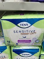 Front view of TENA Sensitive Care pad pack showing packaging, brand, product line, and quantity (12 pads)